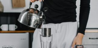 Dlaczego warto mieć filtry wody w zdrowym domu Rodzina cieszy się zdrowiem przy stole, z szklankami czystej wody z filtrów wody w zdrowym domu w otoczeniu roślin.