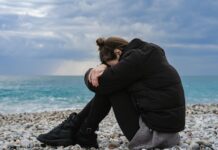 Jak samotność wpływa na zdrowie fizyczne i psychiczne? Osoba siedząca na ławce w parku, otoczona pustką, odzwierciedla, jak samotność wpływa na zdrowie fizyczne i psychiczne