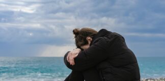 Jak samotność wpływa na zdrowie fizyczne i psychiczne? Osoba siedząca na ławce w parku, otoczona pustką, odzwierciedla, jak samotność wpływa na zdrowie fizyczne i psychiczne