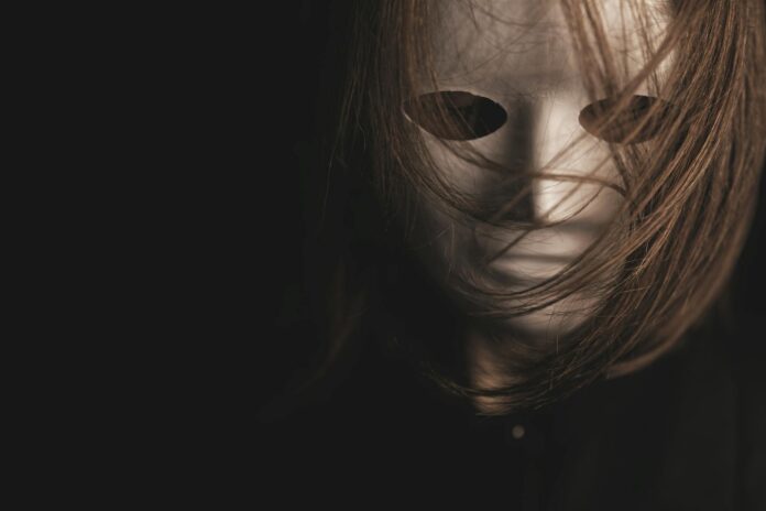 Grupa młodych ludzi korzystających z telefonów, reprezentujących mroczną triadę w kontekście cyberprzemocy w sieci