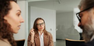 Mroczna triada w kontekście zdolności przywódczych Mroczna triada a zdolności przywódcze; zespół liderów na tle biura, rozmowy i grafiki związane z psychologią liderstwa