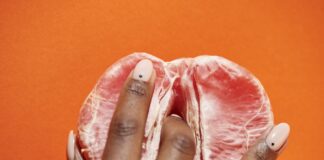 Najlepsze techniki stymulacji łechtaczki dla każdej kobiety Kobieta z uśmiechem eksperymentuje z różnymi technikami stymulacji łechtaczki w kameralnym otoczeniu relaksu