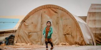 Wspieranie uchodźców a postrzeganie wojny w społeczeństwie Grupa ludzi w różnorodnych ubraniach, niosąca pomoc uchodźcom, ilustruje wspieranie uchodźców a postrzeganie wojny