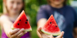 Smaczne i zdrowe przekąski dla dzieci, które pokochają Kolorowe talerze pełne zdrowych przekąsek dla dzieci, takich jak owoce, warzywa i orzechy, na jasnym stole w kuchni
