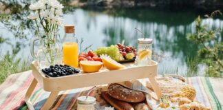 Zdrowe przekąski na piknik, które pokochasz Kolorowe zdrowe przekąski na piknik rozłożone na kocu w parku, otoczone zielenią i promieniami słońca