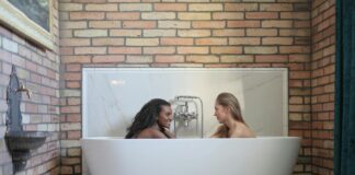 Skuteczne metody na zwiększenie libido u kobiet Kobieta uśmiechająca się w romantycznej scenerii, otoczona świecami, symbolizując zwiększenie libido u kobiet