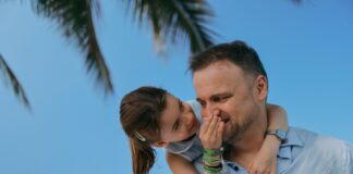 Jak budować więź ojca z córką na co dzień Ojciec z uśmiechniętą córką wspólnie grają w planszówki, budując więź ojca z córką w radosnej atmosferze relaksu