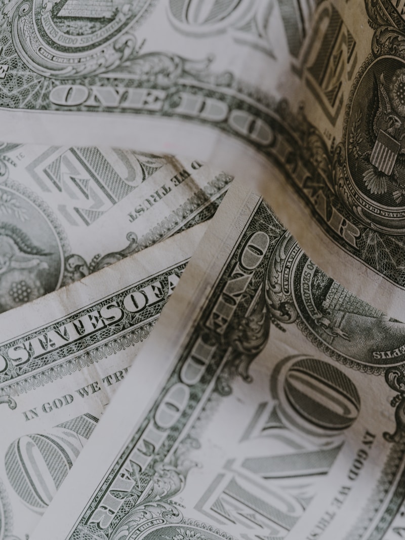 Zbliżenie na dokumenty finansowe oraz laptop, symbolizujące gdzie inwestować pieniądze w dzisiejszych czasach