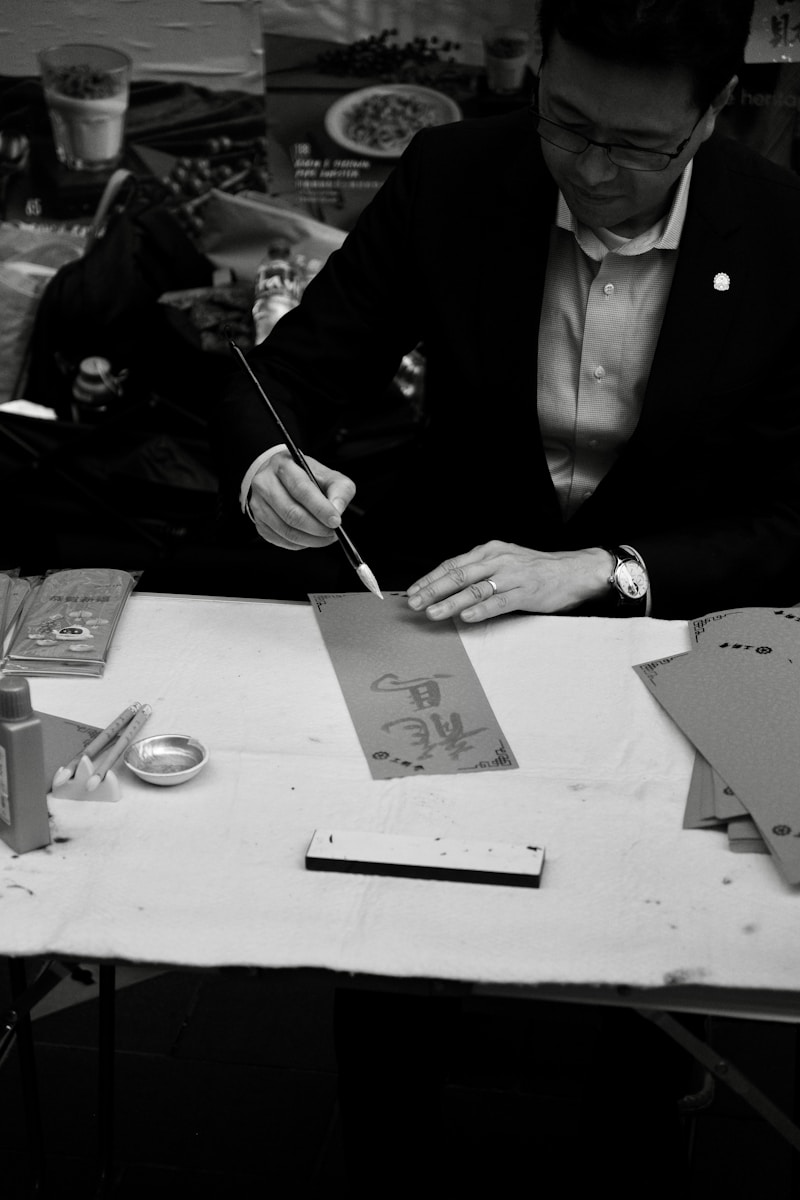 Na biurku leżą narzędzia do kaligrafii: pióra, tusze i notatniki, idealne do twórczej ekspresji i pięknego pisania