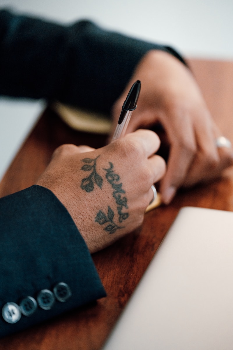 Blisko kadrowane ręce dziecka trzymające kolorowy długopis, skupione na nauce pisania liter na kartce papieru