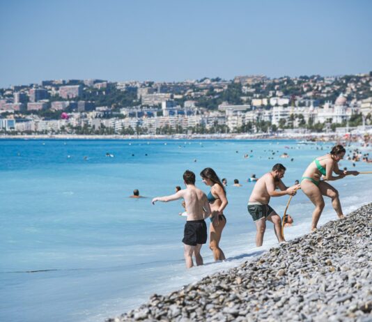 Rodzinne wycieczki nad morze – pomysły na weekend Rodzina bawiąca się na plaży, dzieci budujące zamki z piasku podczas rodzinnej wycieczki nad morze na weekend z dziećmi
